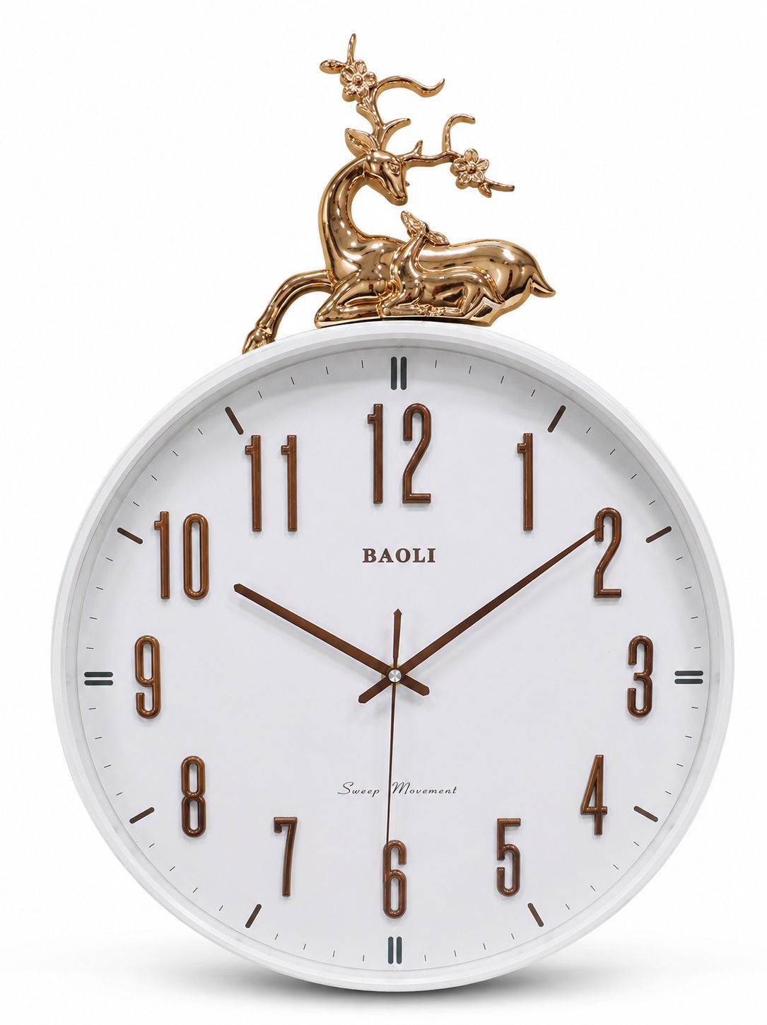 A Baoli wall clock with a white round face, brown Arabic numerals and hands, and a decorative gold deer figurine on top, shown against a plain white background.