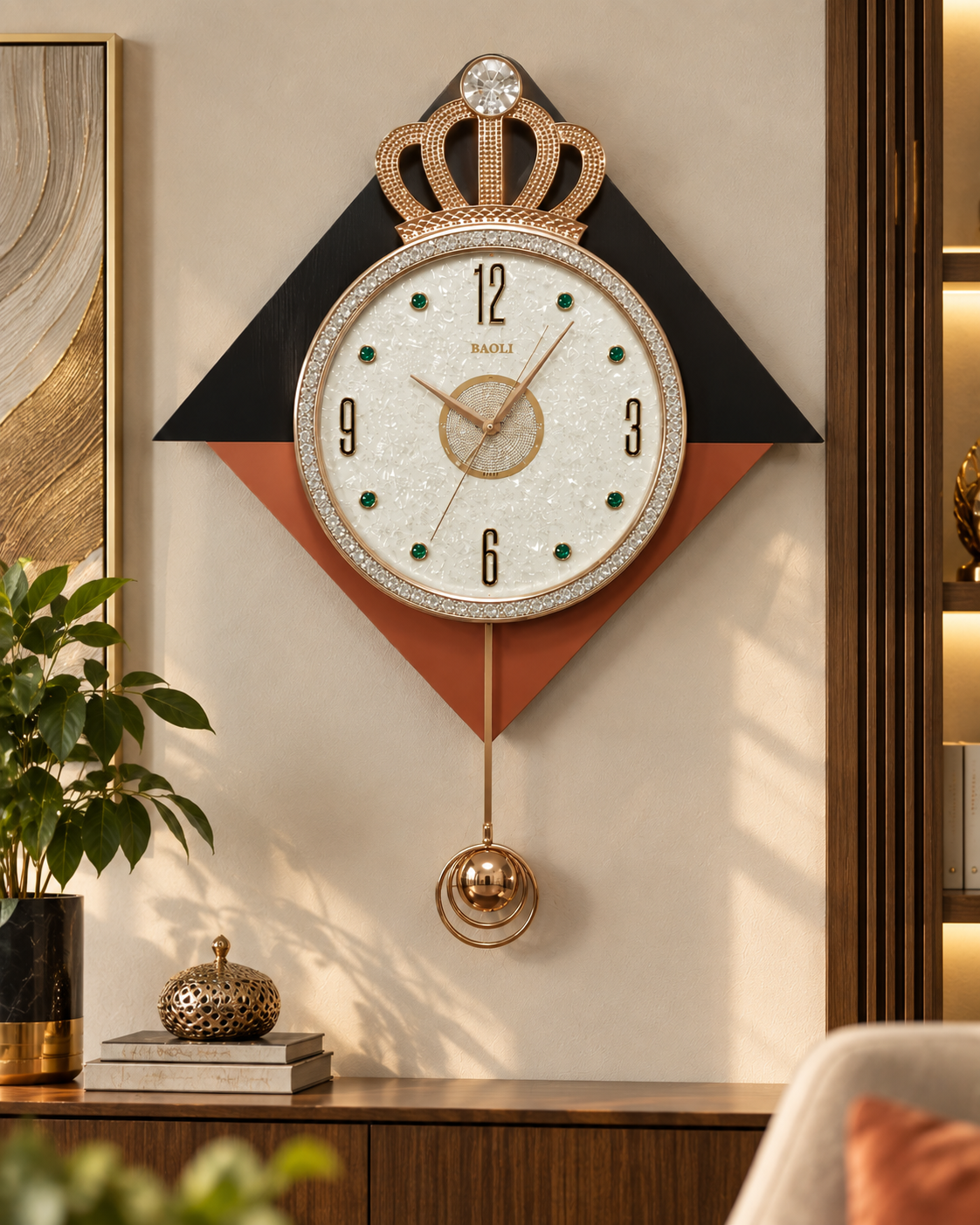 A decorative wall clock with a crown motif and a round white face, shown hanging in a styled interior setting with wood paneling, a plant, books, and wall art.