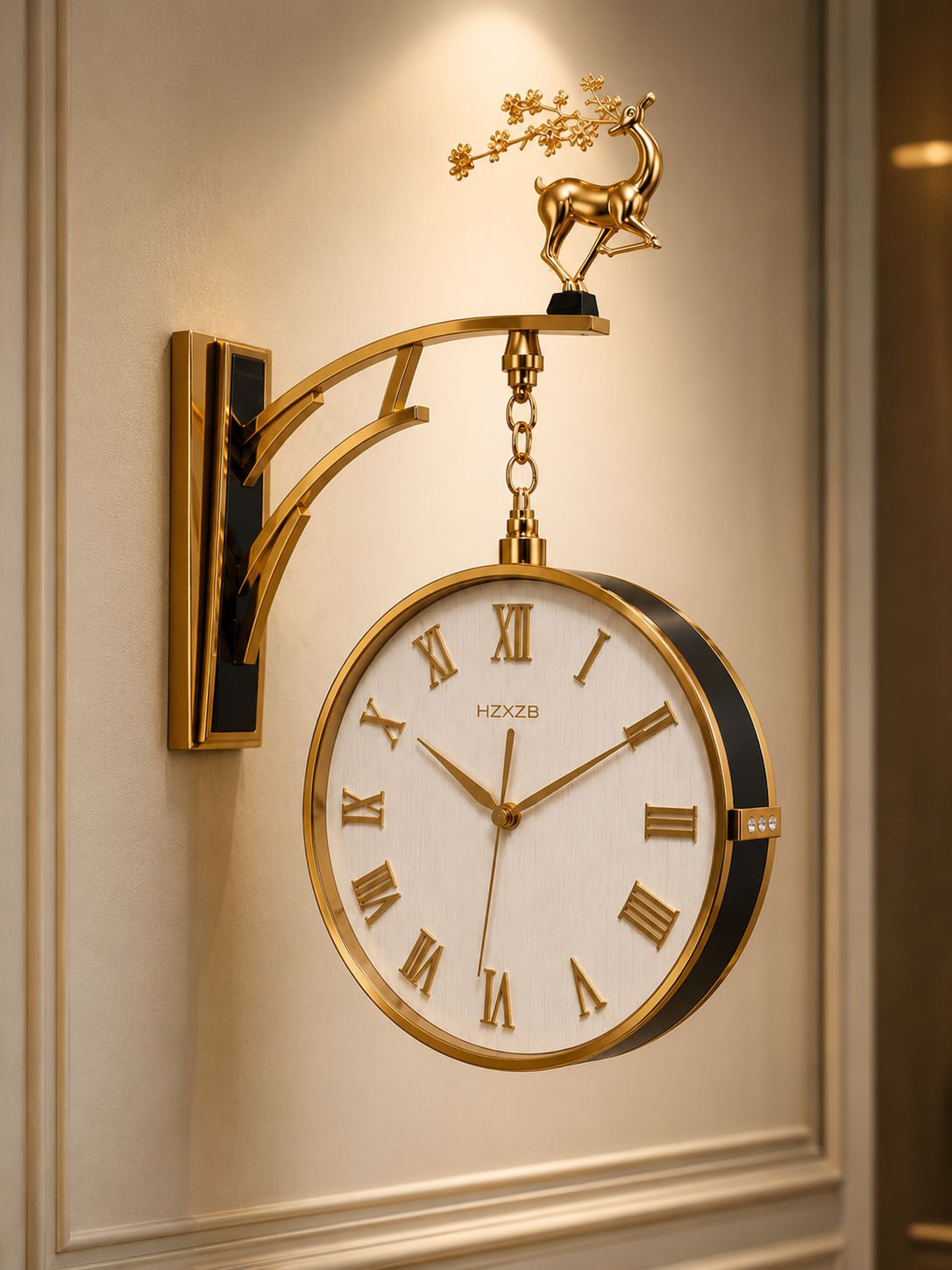 A decorative wall clock with a gold-toned bracket and deer finial, featuring a white dial with gold Roman numerals and a black side accent, mounted on a cream paneled wall.