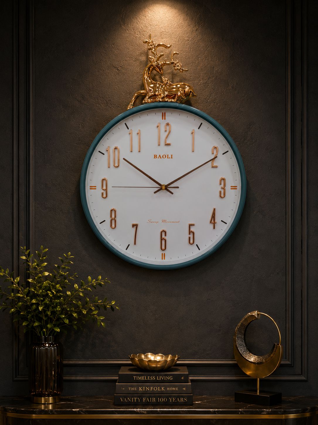 A large round wall clock with a white face, gold Arabic numerals, and a teal-blue rim, mounted on a dark paneled wall. A decorative gold horse sculpture sits above the clock, and a console table with books, a plant, and a small gold sculpture is visible below.