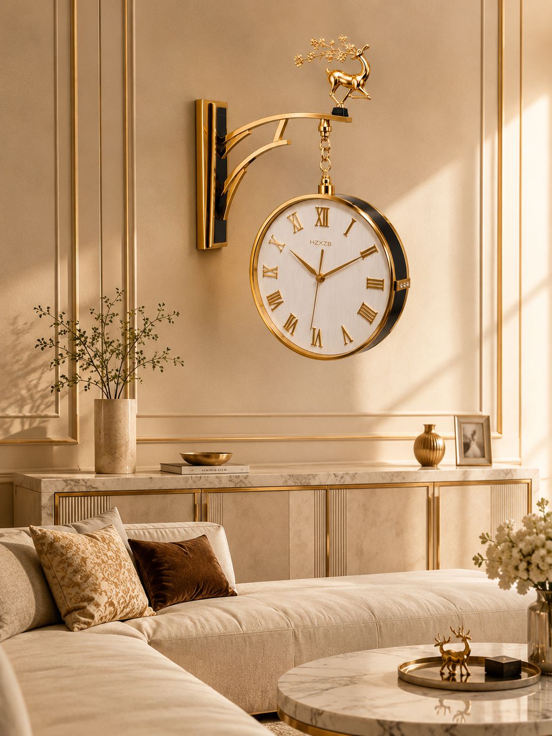 A round wall clock with a gold metal bracket and deer finial, mounted on a beige paneled wall above a marble console in a styled living room.