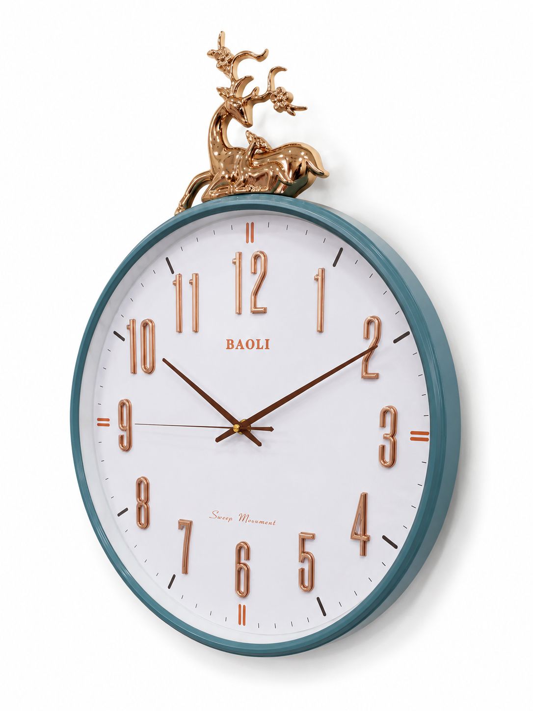 A round wall clock with a white face, teal-blue rim, rose-gold-toned numerals and hands, and a decorative gold deer sculpture at the top, shown on a light gray background.