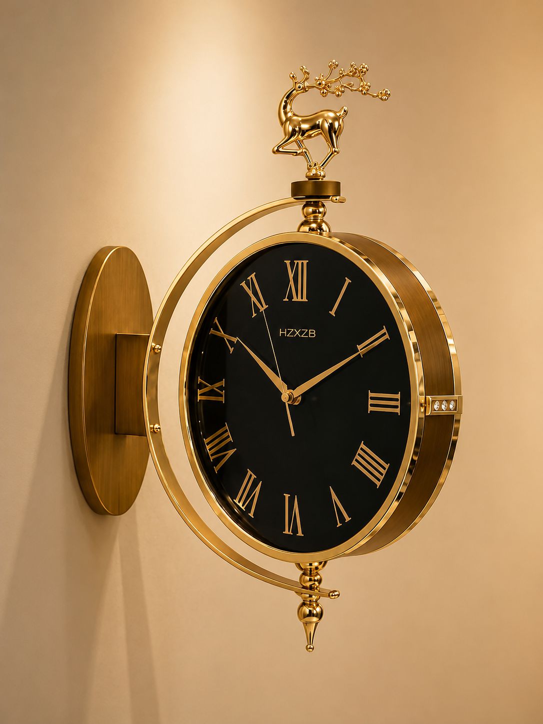 A wall-mounted decorative clock with a round black face, gold Roman numerals, and a polished gold-tone metal frame and wall mount. A small deer figurine sits atop the frame, and the brand name HZXBZ is visible on the clock face.