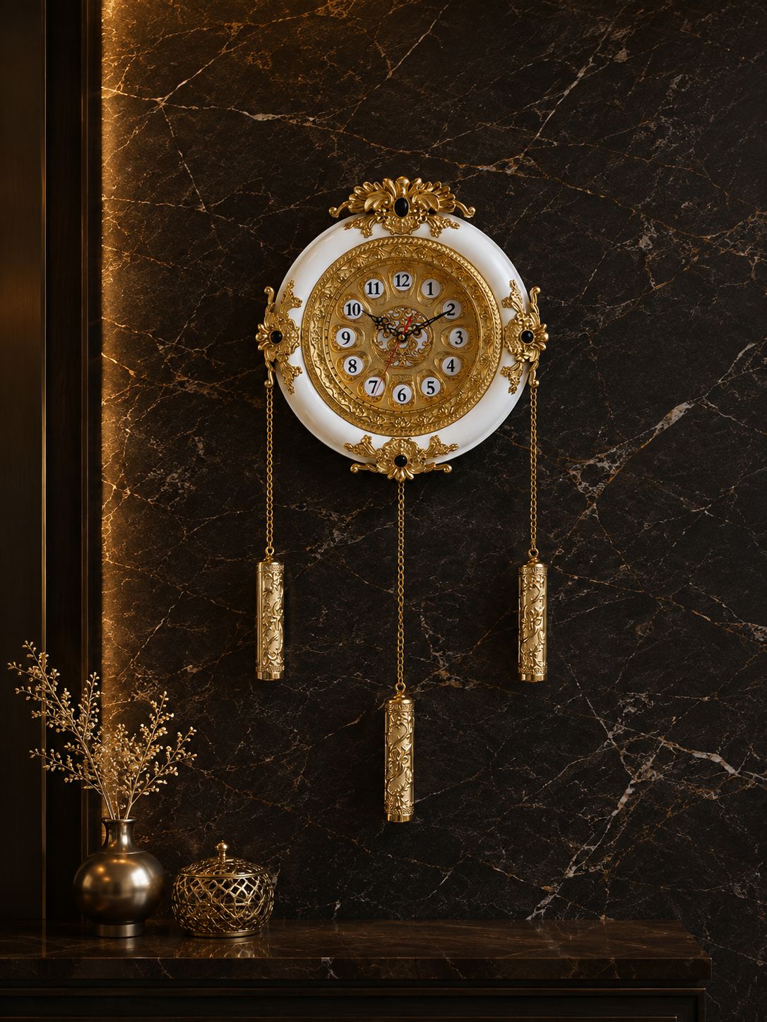 An ornate wall clock with a white circular face and extensive gold filigree detailing, hanging on a dark brown marble wall above a console table with decorative vases.