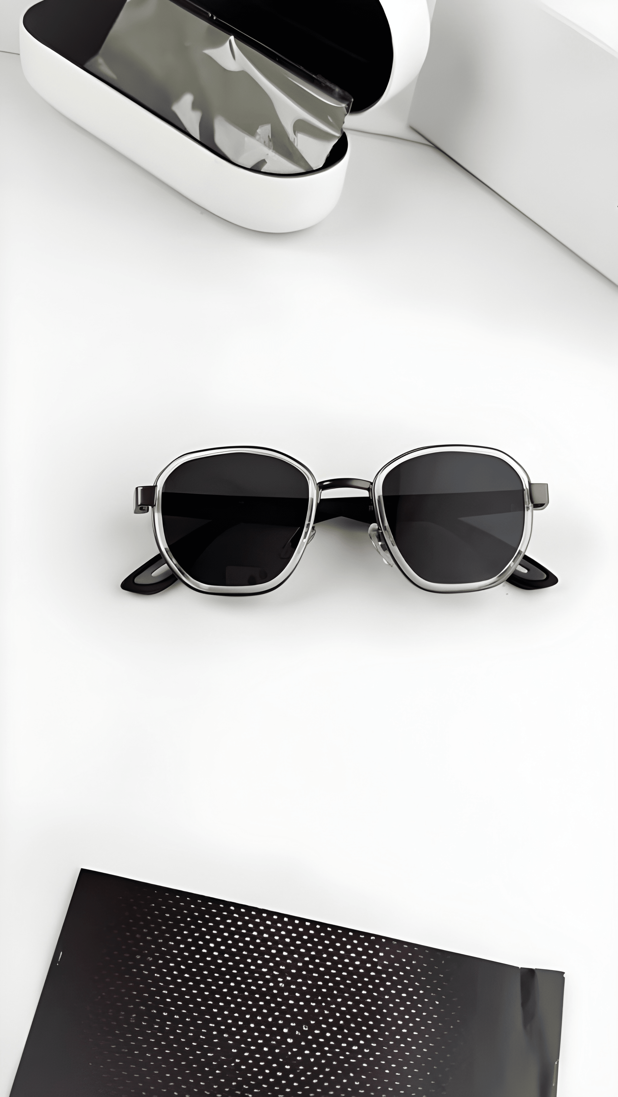 Black sunglasses on a white surface with a black case in the background