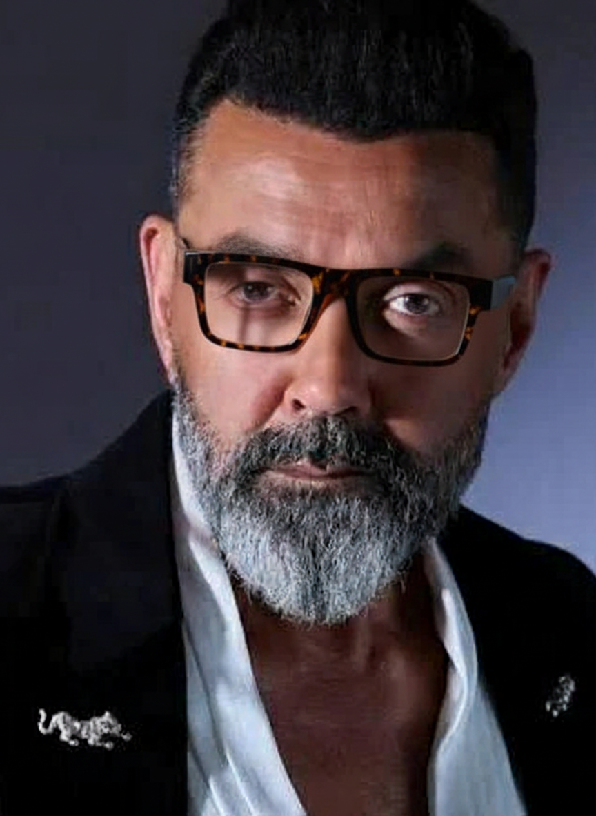 Bollywood actor Bobby Deol wearing tortoiseshell rectangle sunglasses in a snake print shirt.