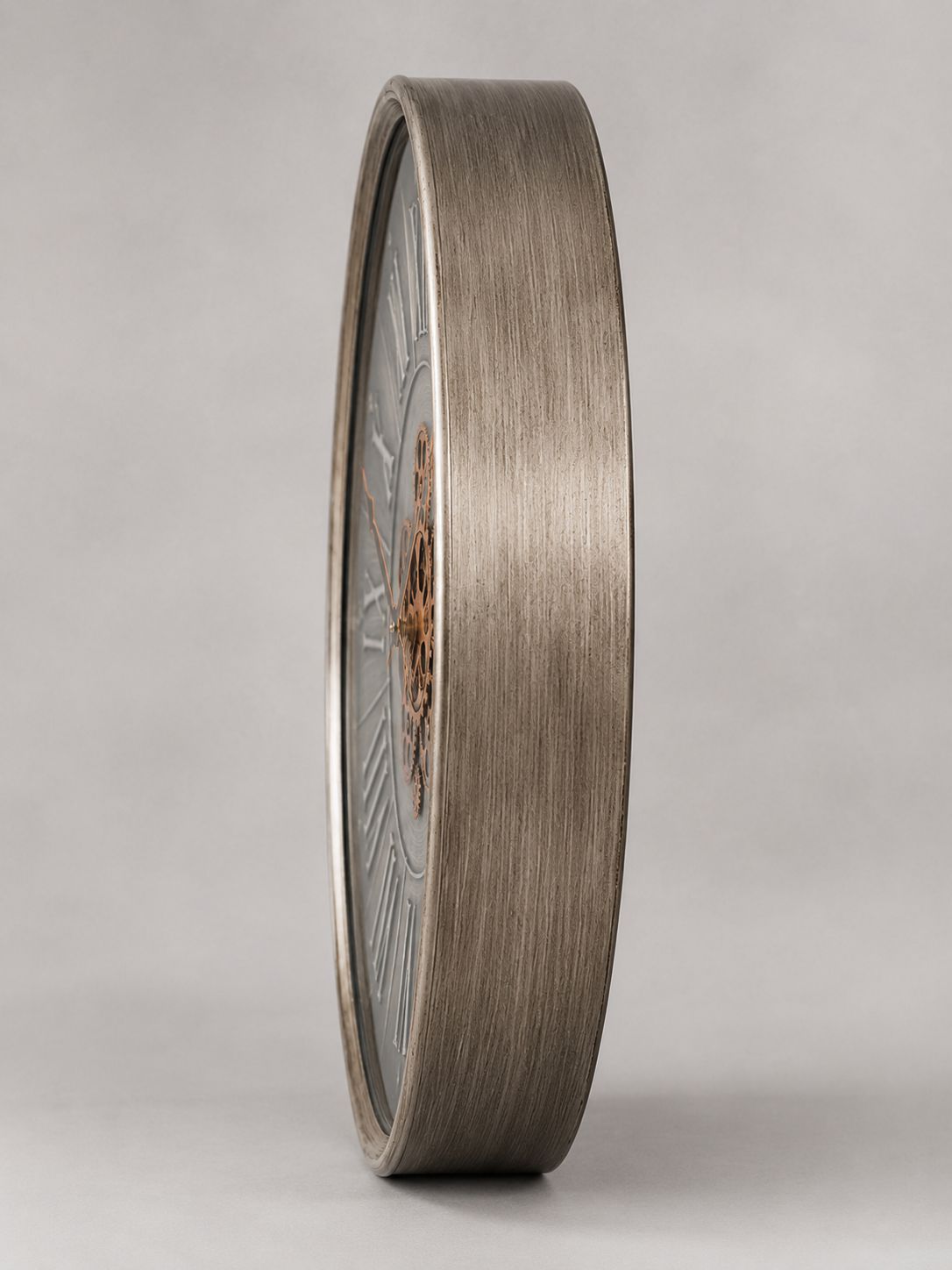 Bronze-colored circular object with detailed design on a gray background