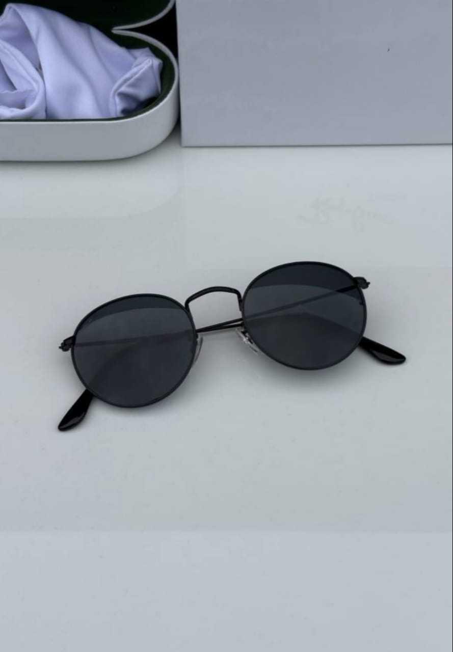 Classic black round metal sunglasses with dark lenses on a clean white background.