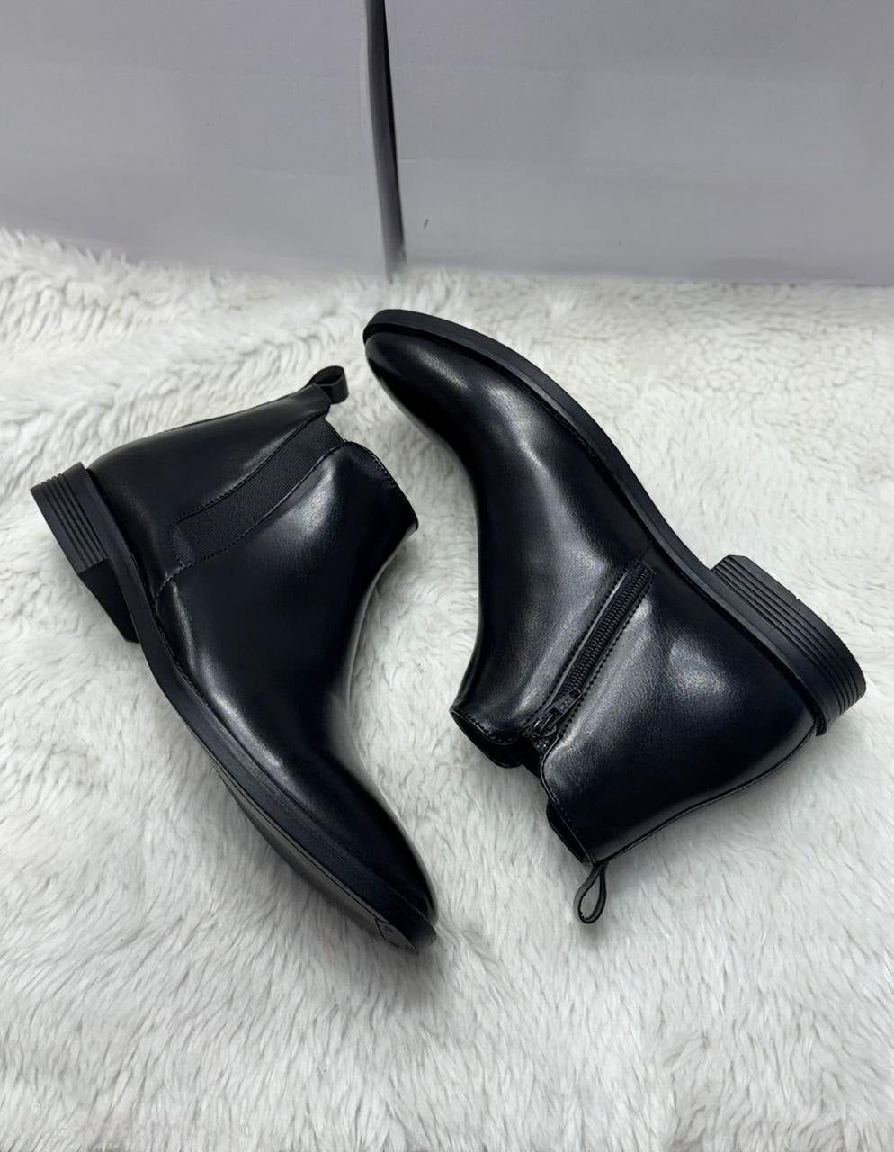 Close-up of Black Chelsea Boot side profile with functioning zipper and elastic panel