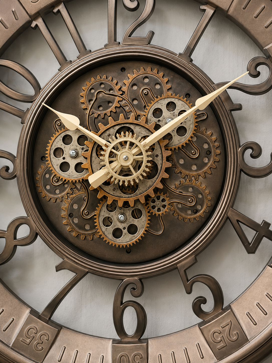 Close-up of a decorative wall clock with a visible mechanical gear system, bronze-toned numerals, and metallic hands.