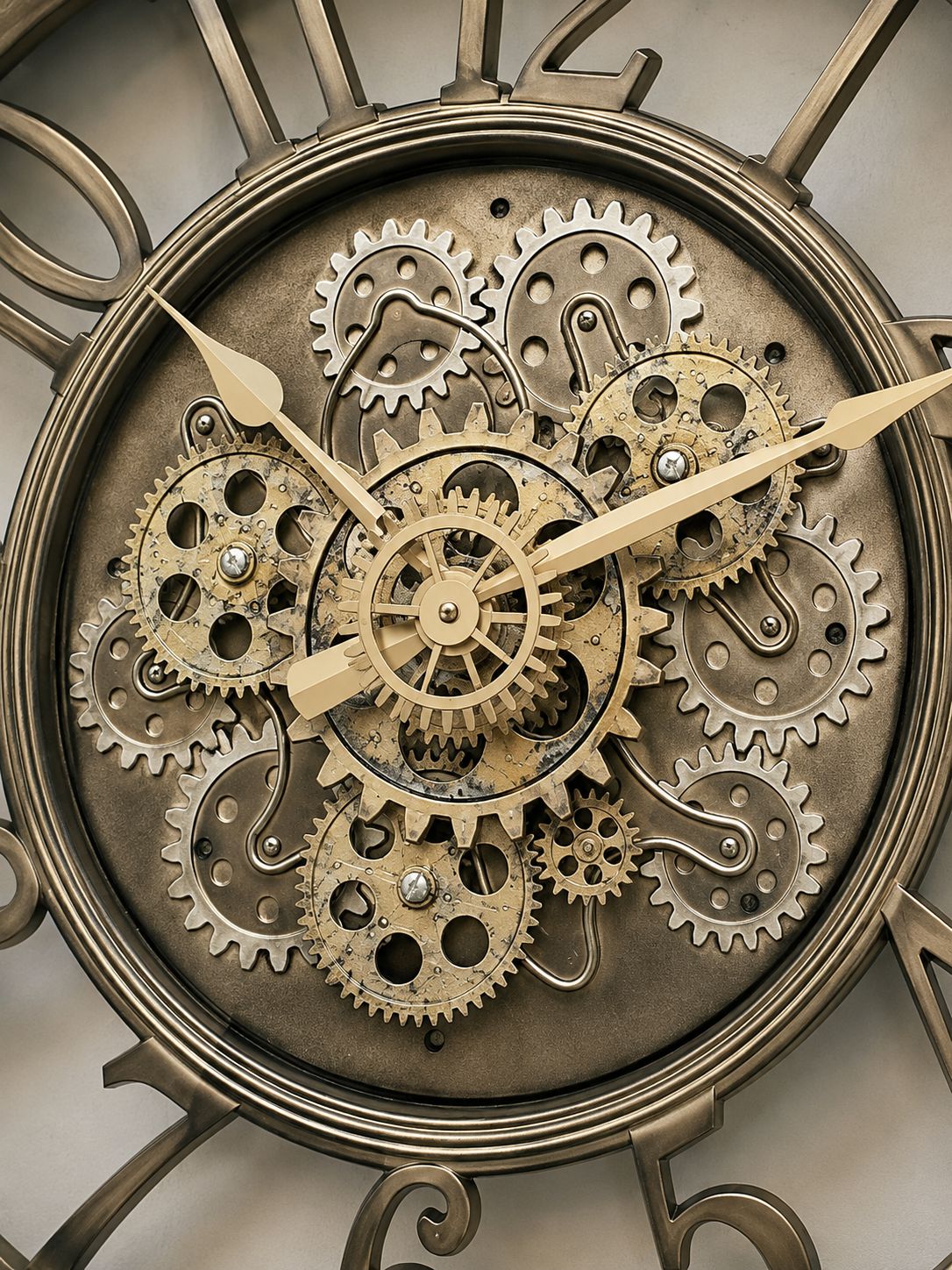 Close-up of a steampunk-style wall clock face with exposed metal gears, cogs, and clock hands in aged brass, bronze, and silver tones.