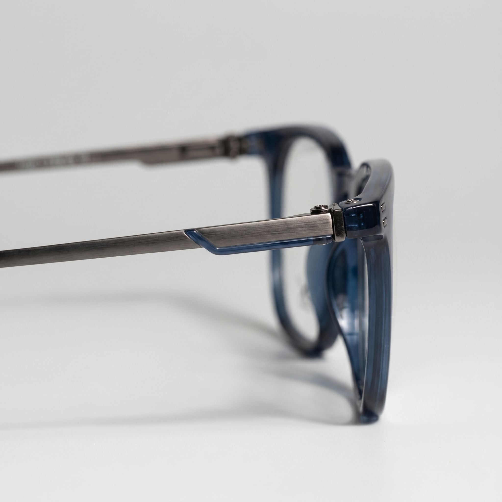 Close-up of gunmetal metal temple and hinge detail on blue eyeglasses