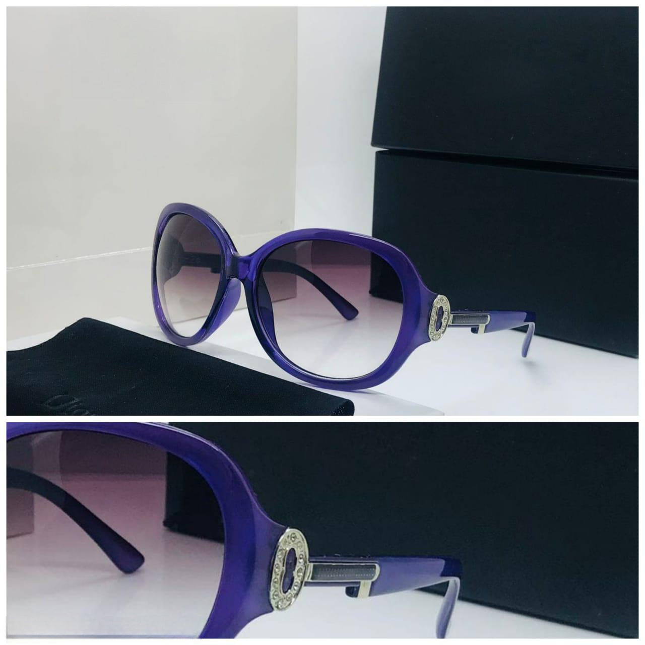 Close-up of the purple sunglasses showing the decorative gold metal and sparkling accent on the side.