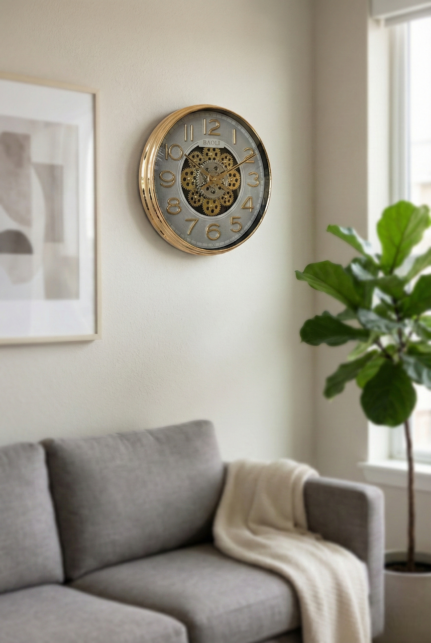 Decorative wall clock on a wall above a gray sofa with a plant in the corner.