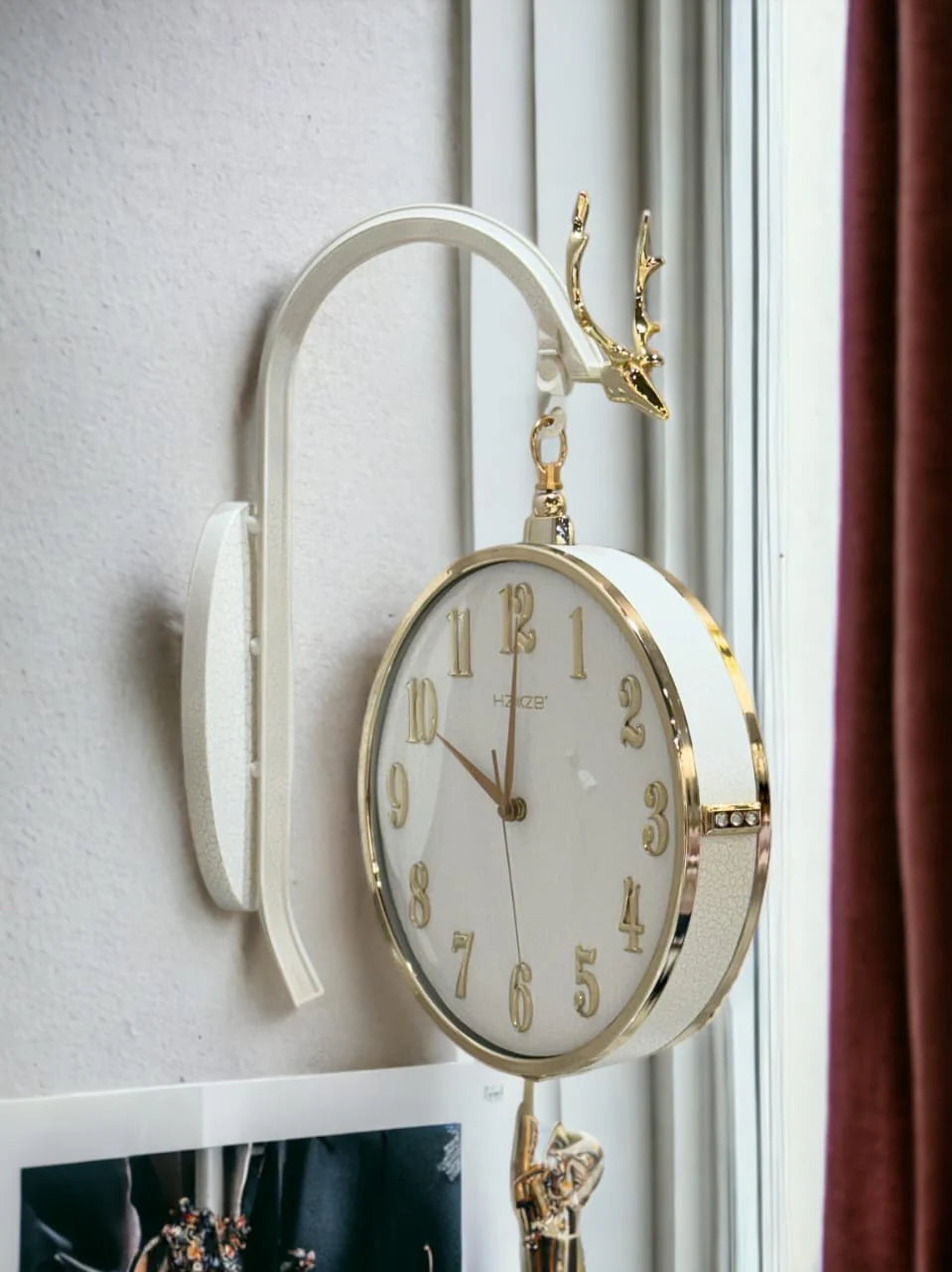 Decorative wall clock with gold accents on a white wall.