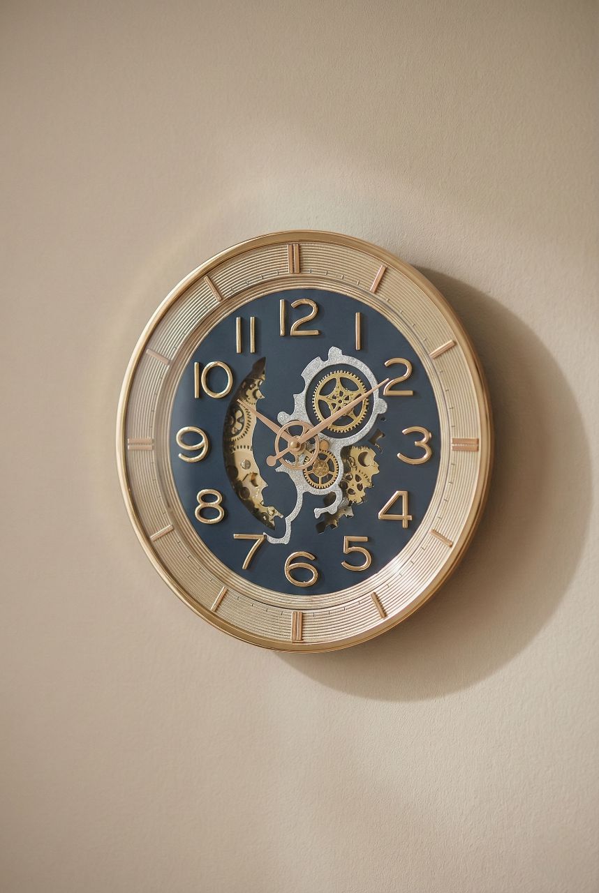 Decorative wall clock with intricate design on a beige wall