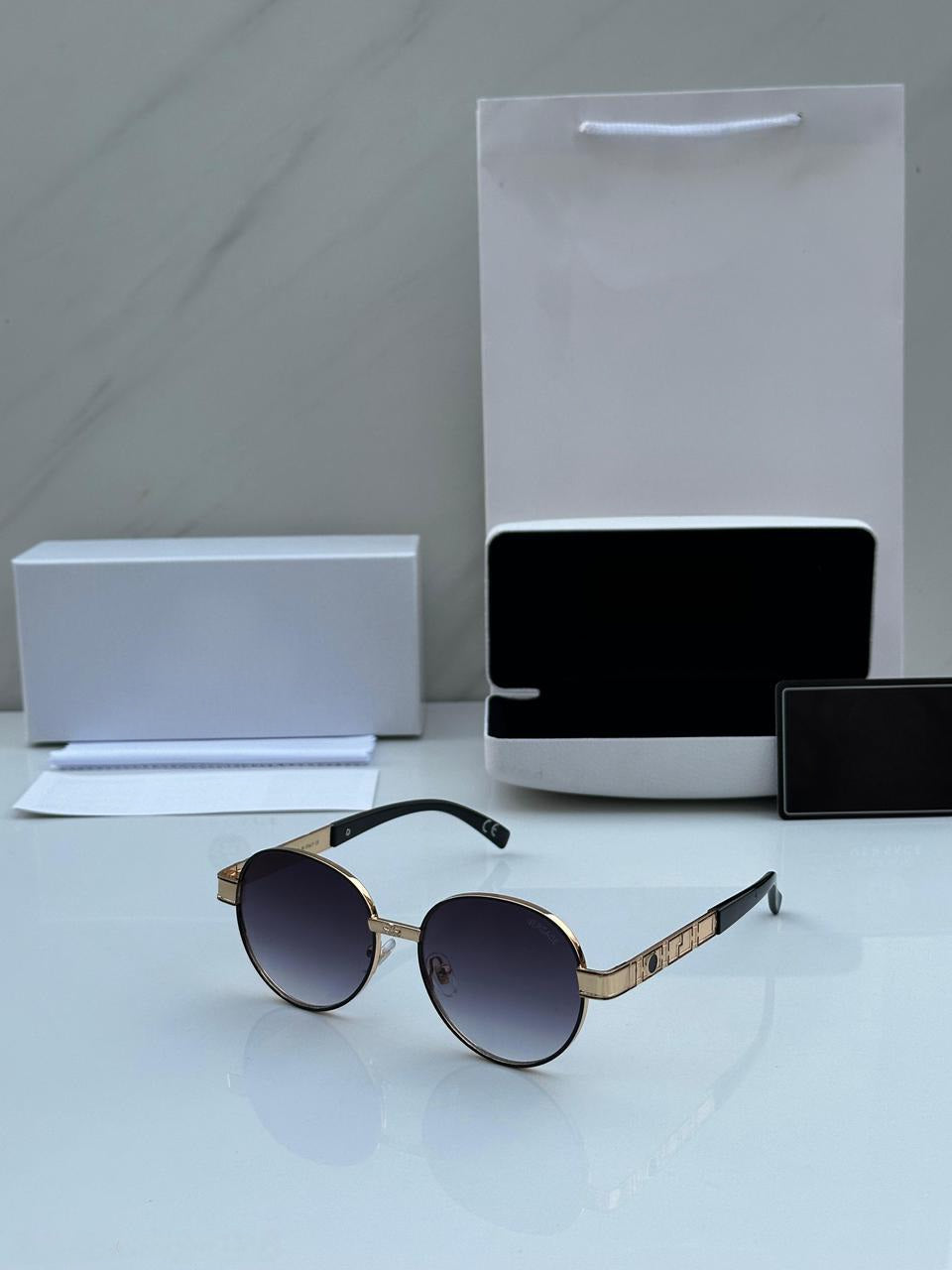 Gold Round Sunglasses with gradient lenses, displayed with protective white case and box.