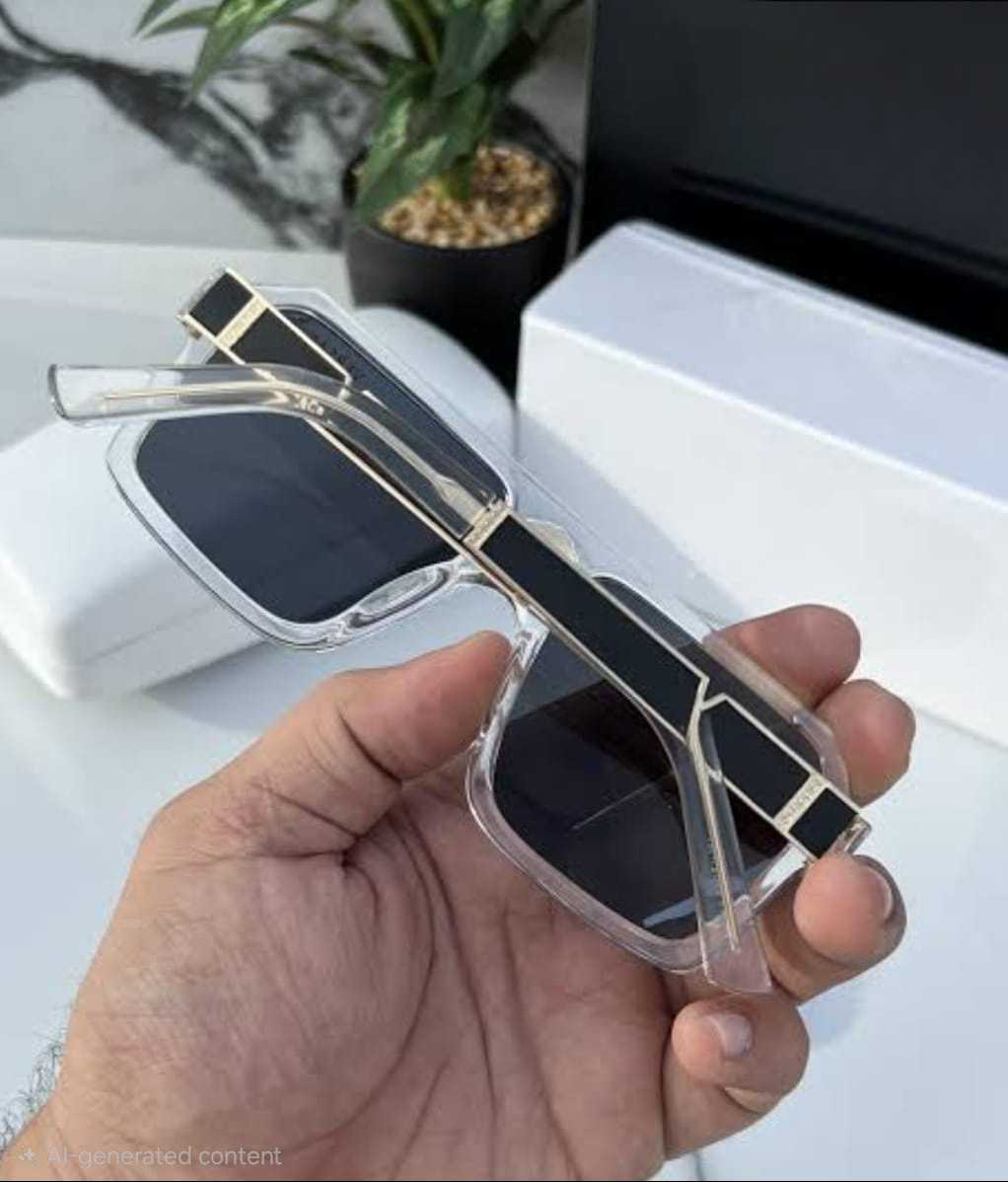Hand holding transparent square sunglasses, showing gold accents and temple design.