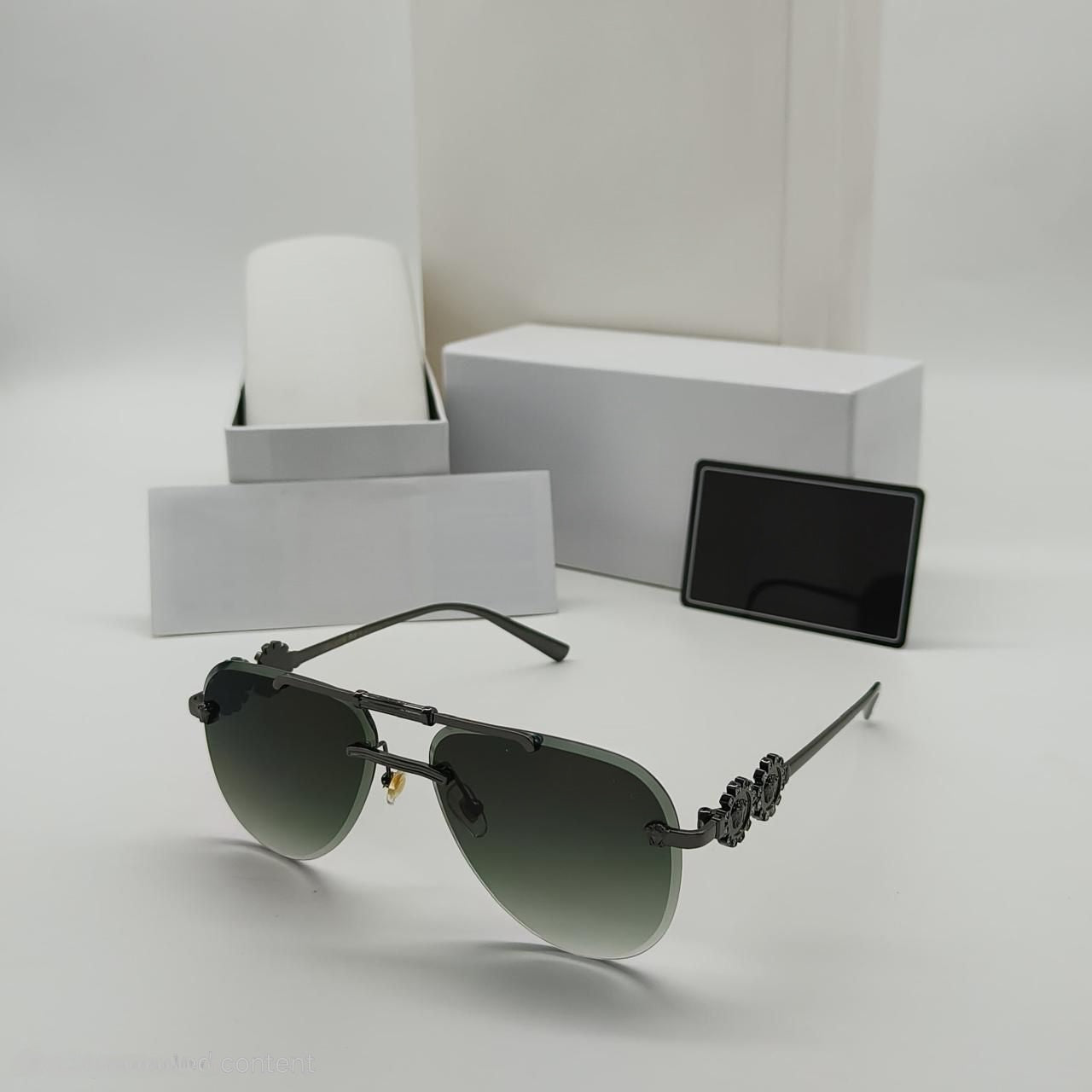 Men's rimless pilot sunglasses with gunmetal frame and dark green gradient lens, featuring unique temple detail.