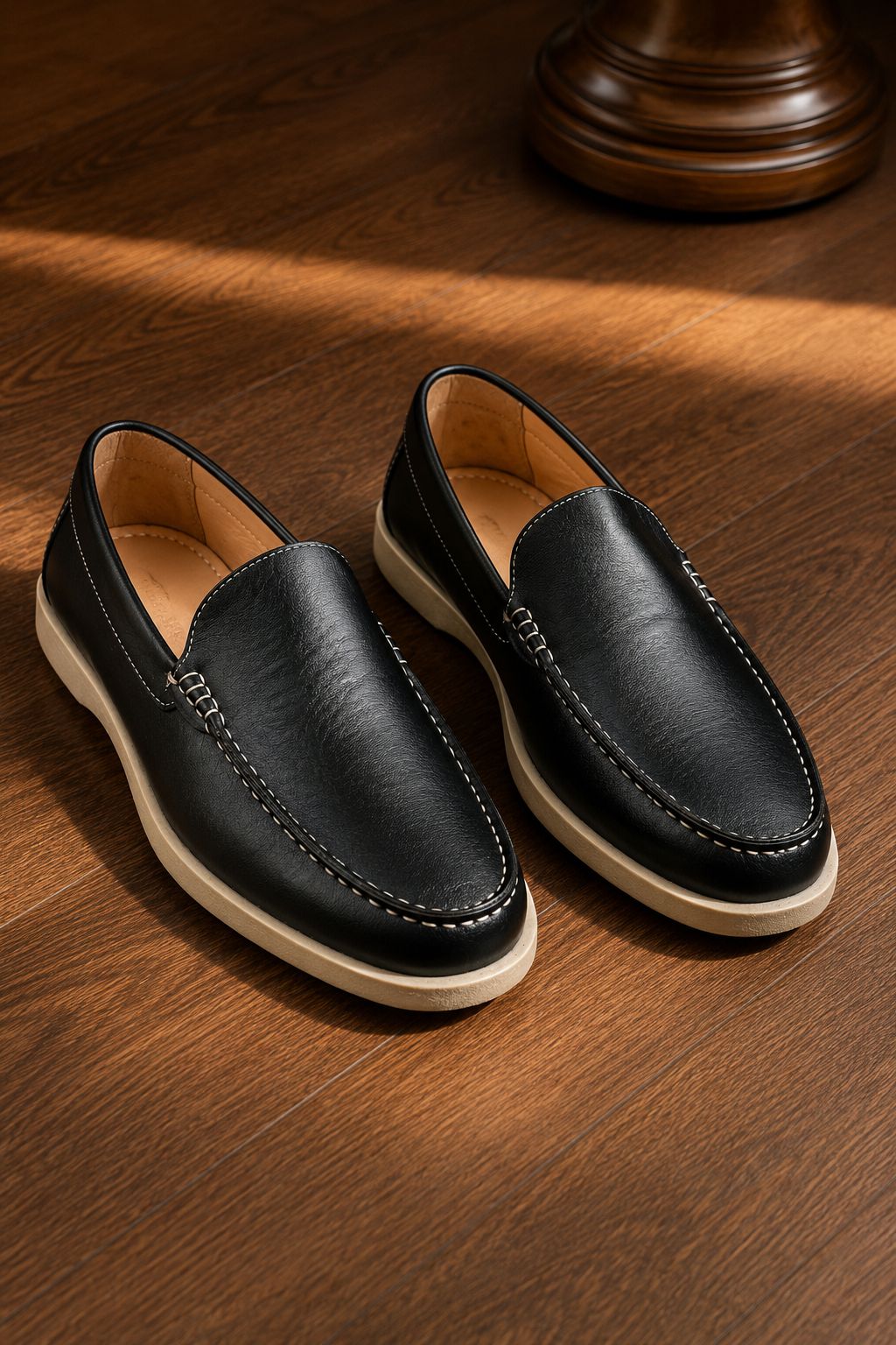 Pair of black leather loafers on a wooden surface
