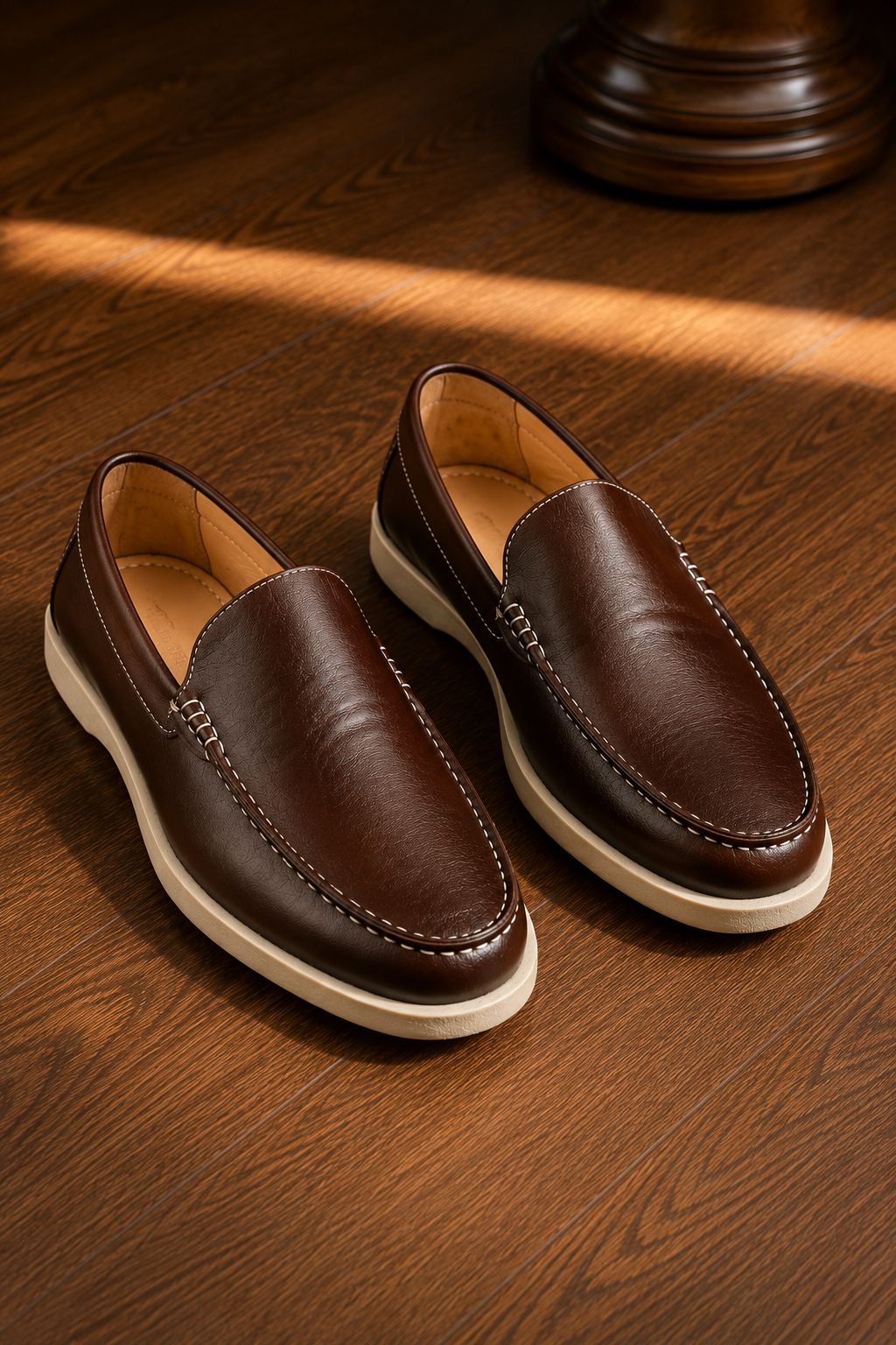 Pair of brown leather loafers on a wooden surface