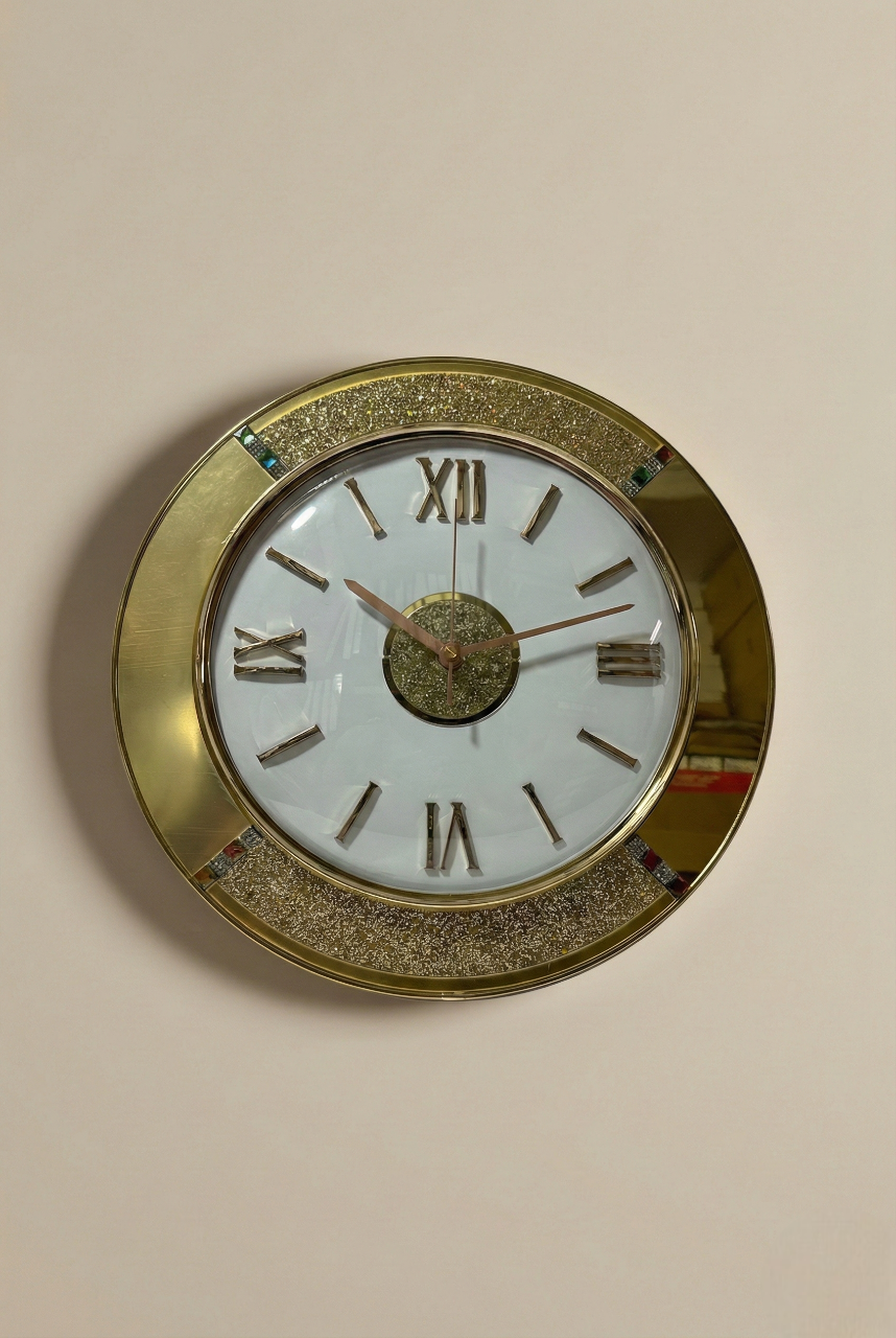 Round wall clock with gold frame and Roman numeral markers on a beige wall.