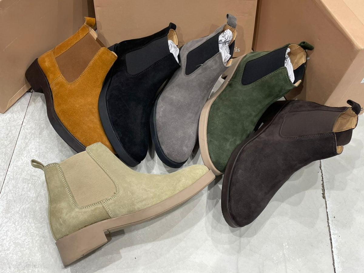 Set of suede ankle boots in various colors on a light background