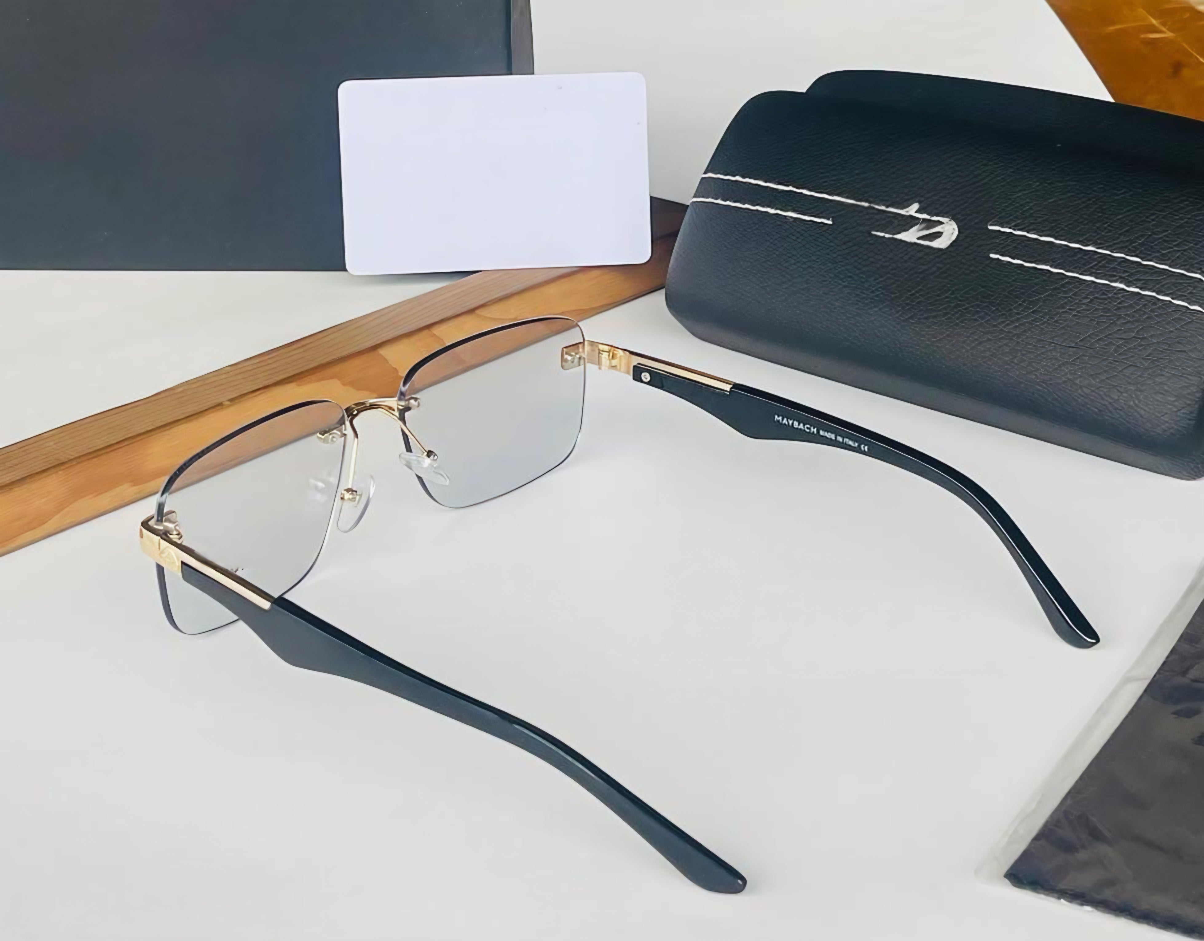 Side profile of the black aviator sunglasses showing the thin golden metal temple and frame detail.