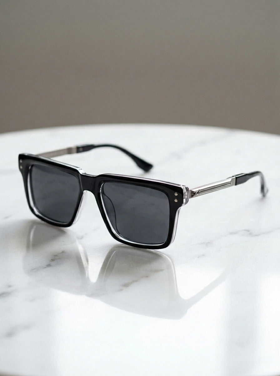 Premium black square sunglasses placed on marble table in luxury workspace setup