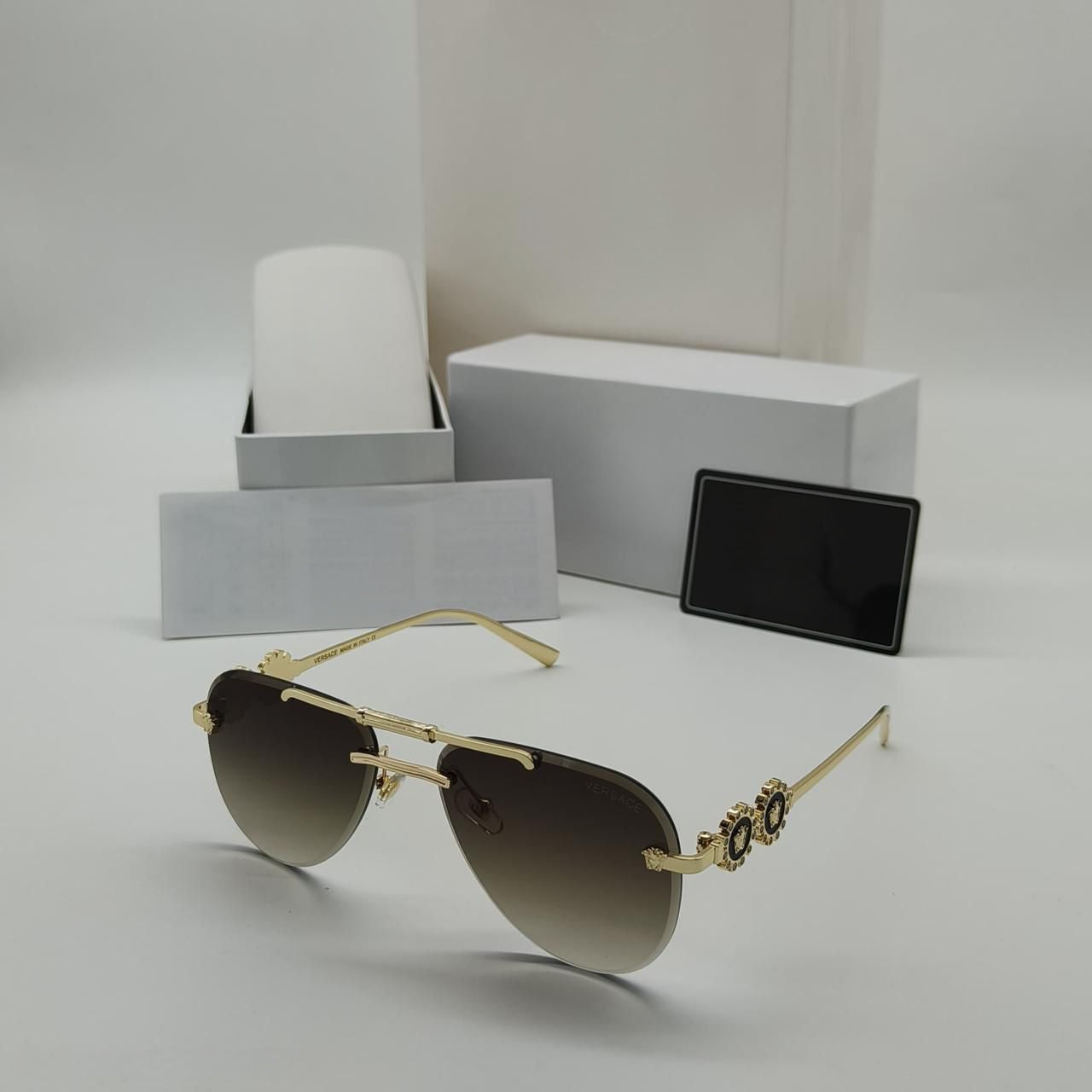 Trendy square navigator sunglasses in black and gold metal frame with brown gradient lens and hard protective case.