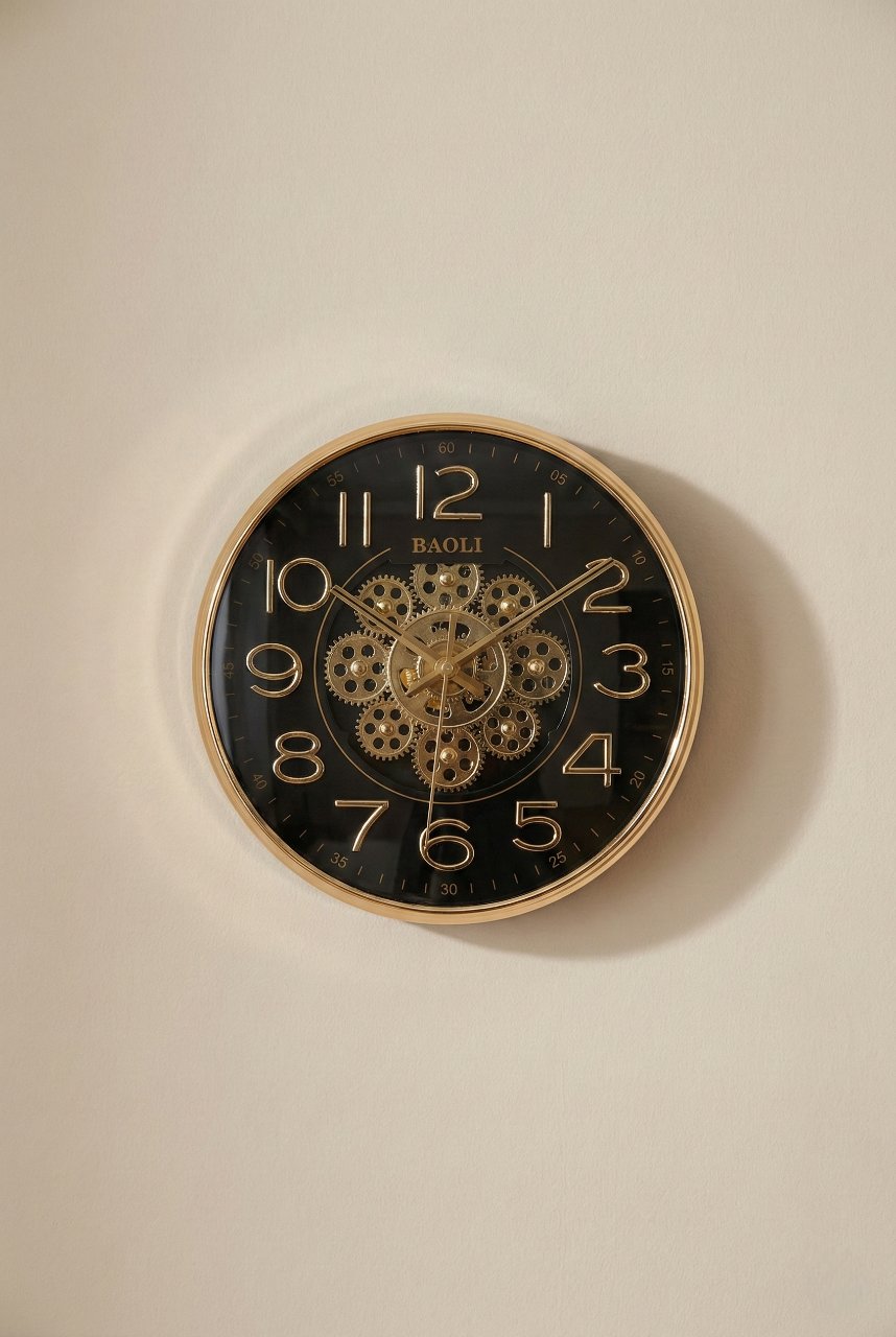 Wall clock with gold casing and black face on a beige wall