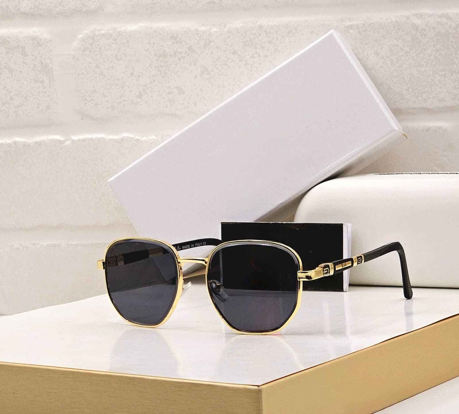 Close-up of Golden & Black Hexagon Aviator Sunglasses on a display, next to a photo of Shahrukh Khan wearing the same style