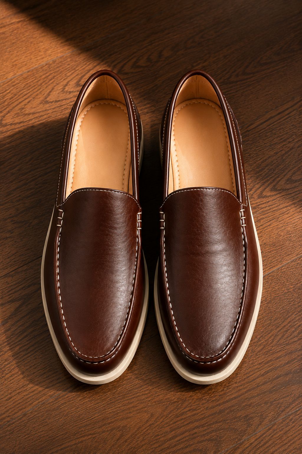 Pair of brown leather loafers on a wooden surface